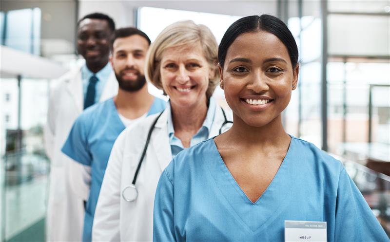 Four healthcare professionals, two women and 2 men in white and blue uniform